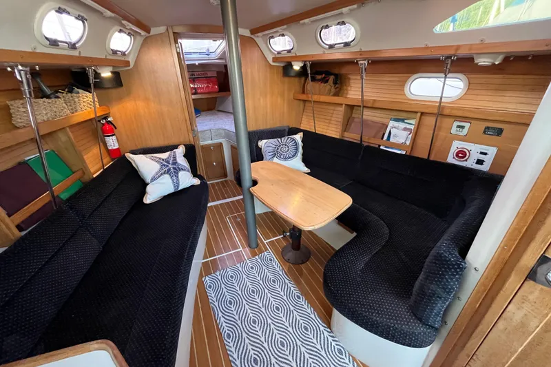 Slide: The Image of Interior of 2005 Catalina 320 sailboat with cozy seating and wooden finishes. - 2