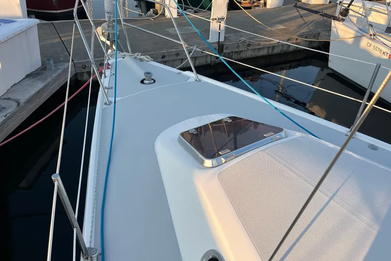 Slide: The Image of Deck of 2005 Catalina 320 sailboat docked at marina, featuring hatch and rigging. - 17