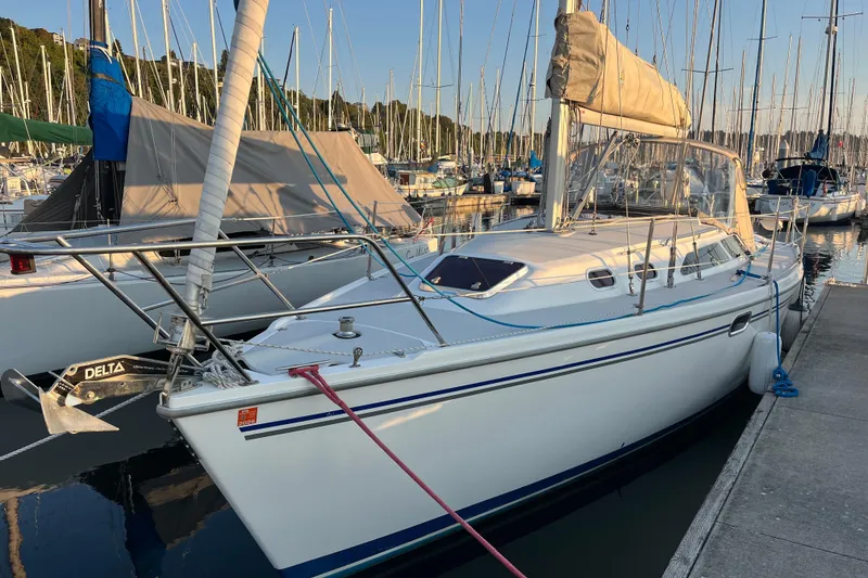 The Image of Catalina 320 sailboat, 2005 model, docked in a marina with surrounding boats. - 0