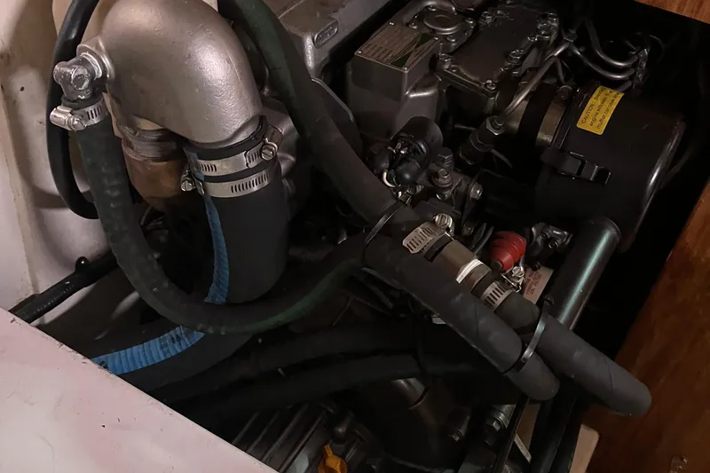 Slide: The Image of Engine compartment of a 2005 Catalina 320 sailboat, showing hoses and mechanical components. - 33
