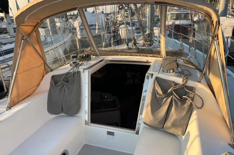 Slide: The Image of Cockpit of a 2005 Catalina 320 sailboat with tan canopy and storage bags. - 26