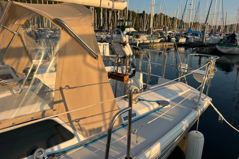 Slide: The Image of 2005 Catalina 320 sailboat docked in a marina, surrounded by other boats. - 24