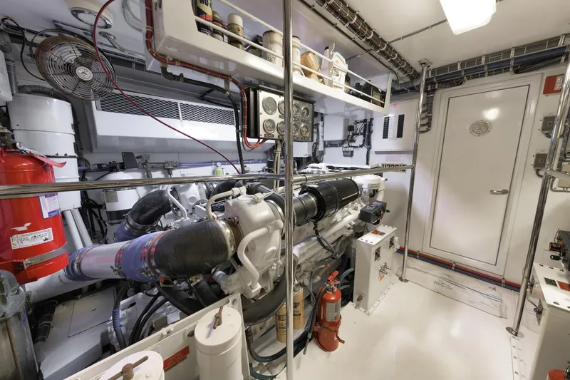 Slide: The Image of Engine room of a 2002 Hatteras Motor Yacht, featuring machinery and safety equipment. - 43