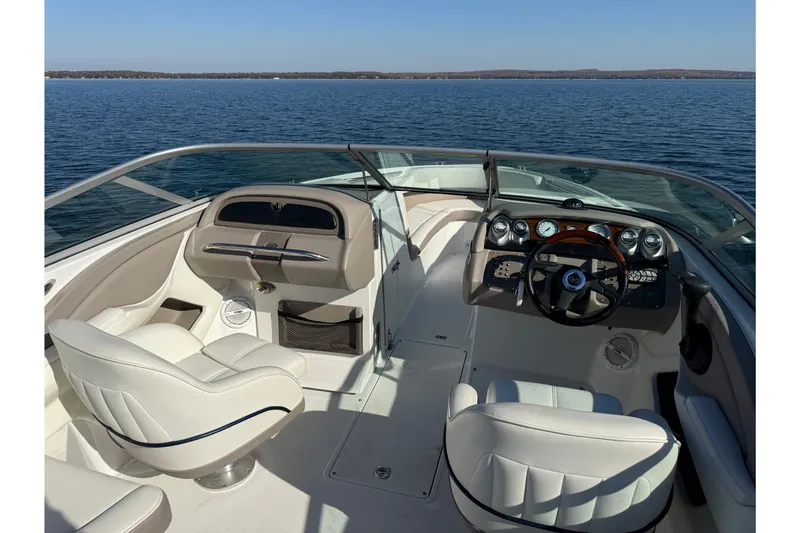 Slide: The Image of Interior of a 2004 Cobalt 250 boat with white seating and dashboard controls. - 19