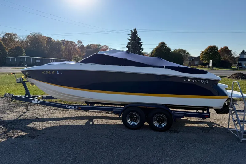 Slide: The Image of 2004 Cobalt 250 boat on trailer, covered, parked outdoors. - 7