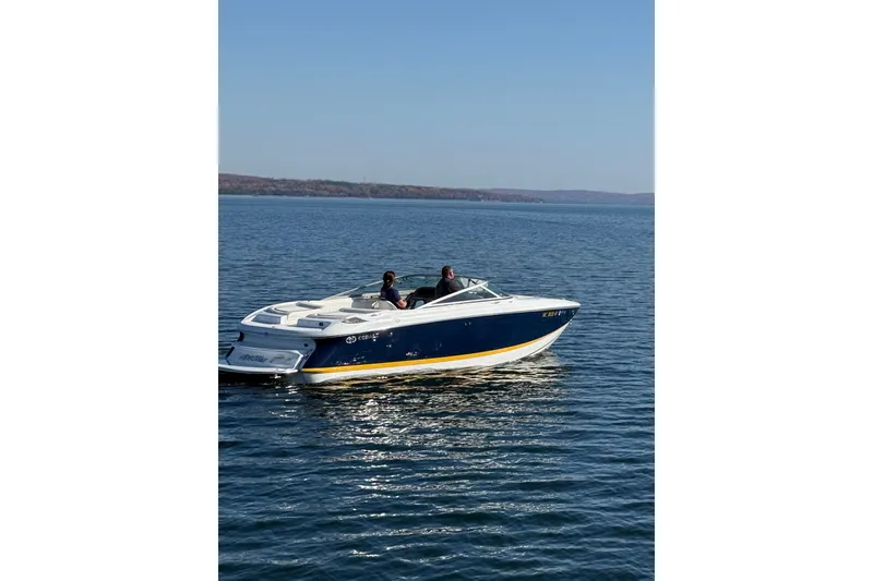 Slide: The Image of 2004 Cobalt 250 boat cruising on a calm lake under clear blue skies. - 3