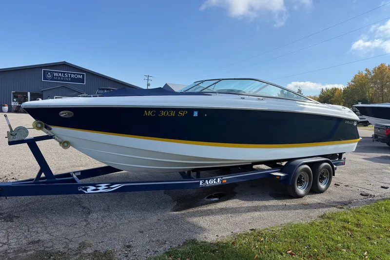 Slide: The Image of 2004 Cobalt 250 boat on trailer at Walstrom Marine under clear sky. - 11