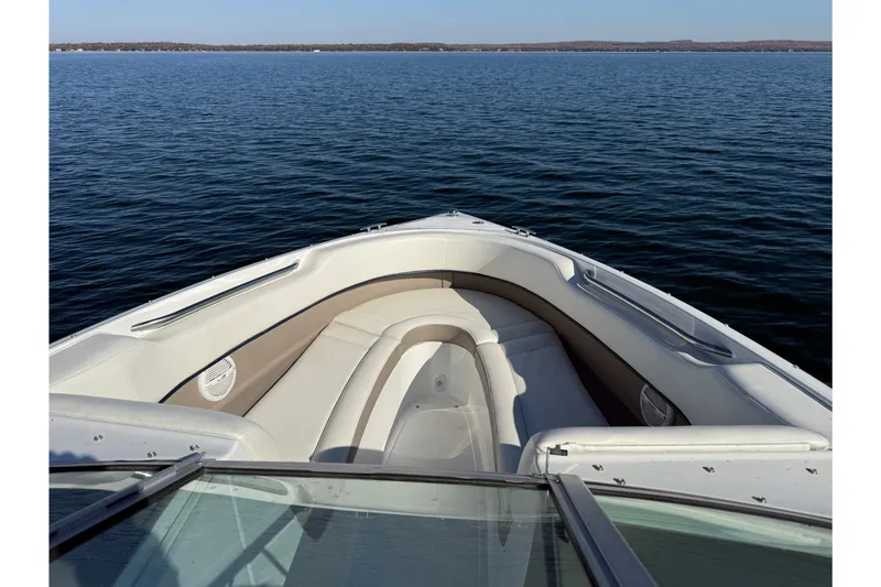 Slide: The Image of 2004 Cobalt 250 boat interior with lake view, featuring white seating and calm waters. - 18