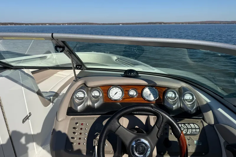 Slide: The Image of Steering console of a 2004 Cobalt 250 boat on a calm lake. - 16
