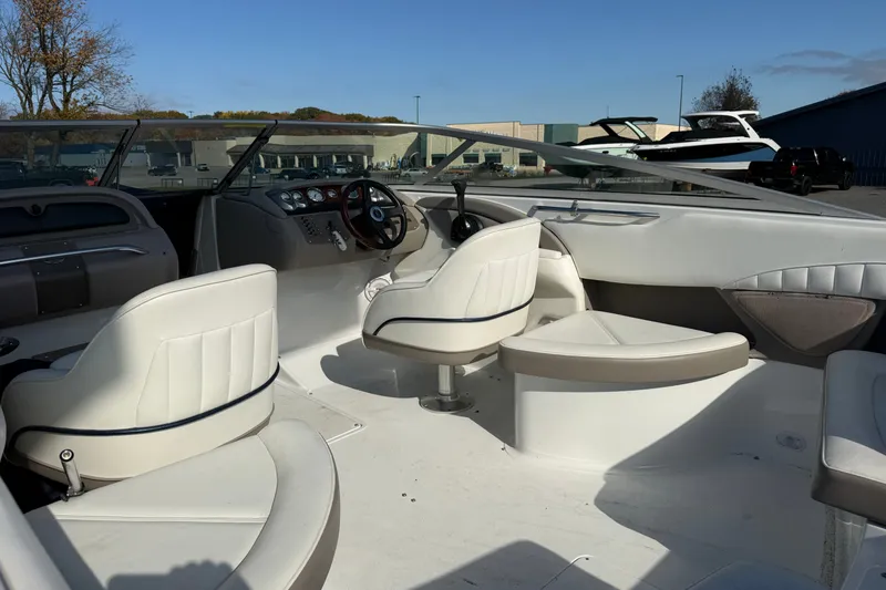 Slide: The Image of Interior of a 2004 Cobalt 250 boat with white seating and steering wheel. - 15