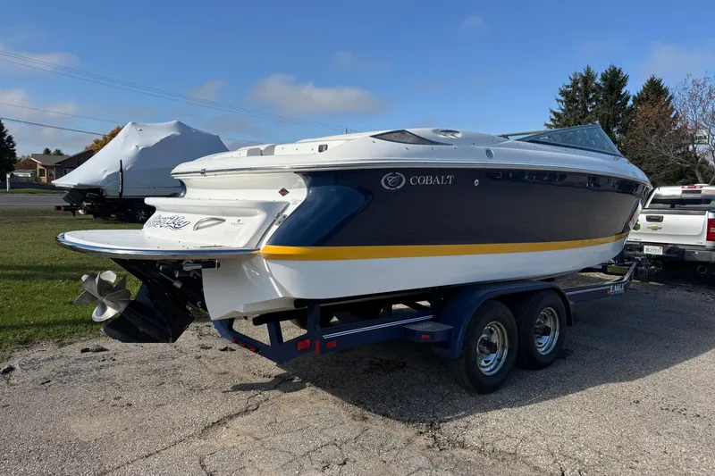 Slide: The Image of 2004 Cobalt 250 boat on trailer, parked outdoors on a sunny day. - 9