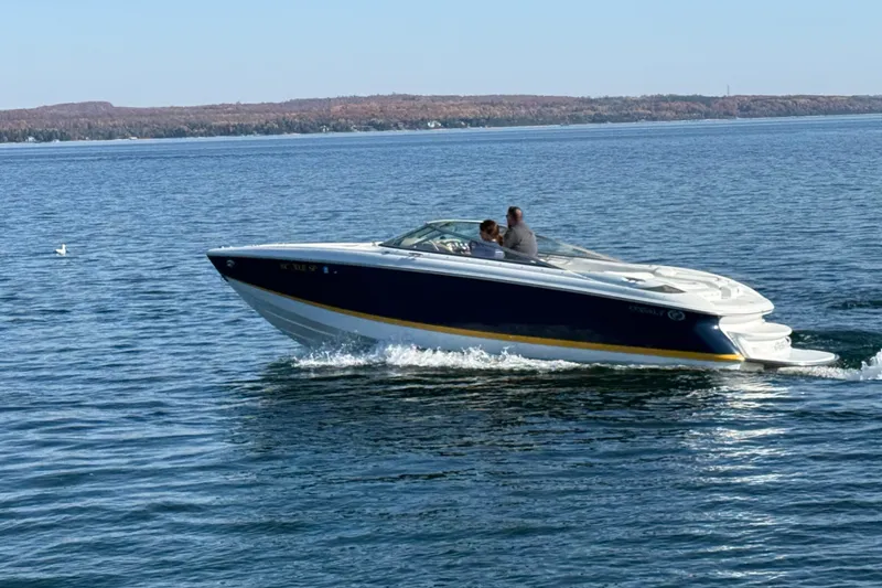 Slide: The Image of 2004 Cobalt 250 boat cruising on a serene lake with distant shoreline. - 4