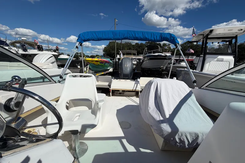 Slide: The Image of 1994 Grady-White Tournament 197 boat interior with blue canopy, docked under a sunny sky. - 16