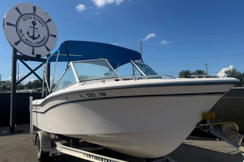 The Image of 1994 Grady-White Tournament 197 boat on trailer, blue canopy, sunny day. - 0