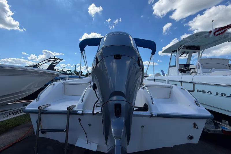 Slide: The Image of 1994 Grady-White Tournament 197 boat with outboard motor, docked under a blue sky. - 4
