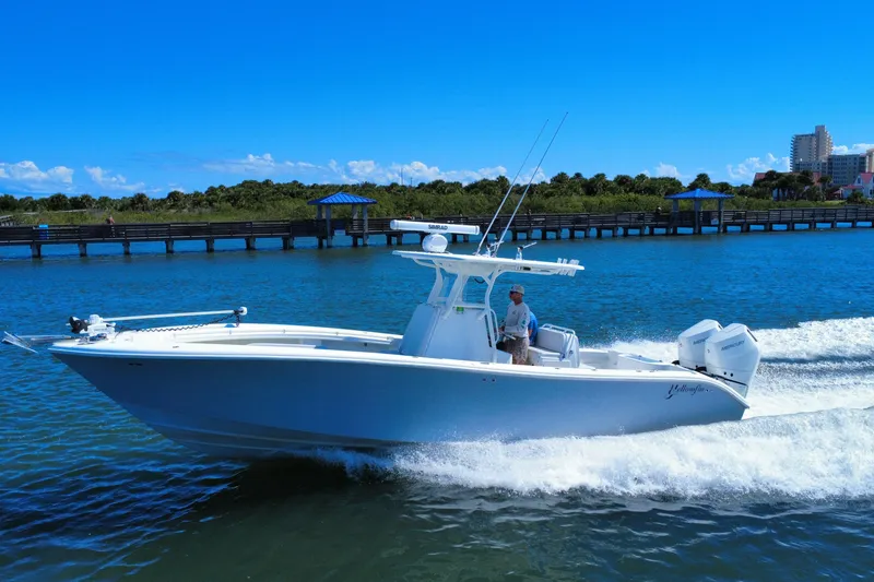 Slide: The Image of 2010 Yellowfin 32 Offshore boat cruising on a sunny day near a scenic pier. - 5