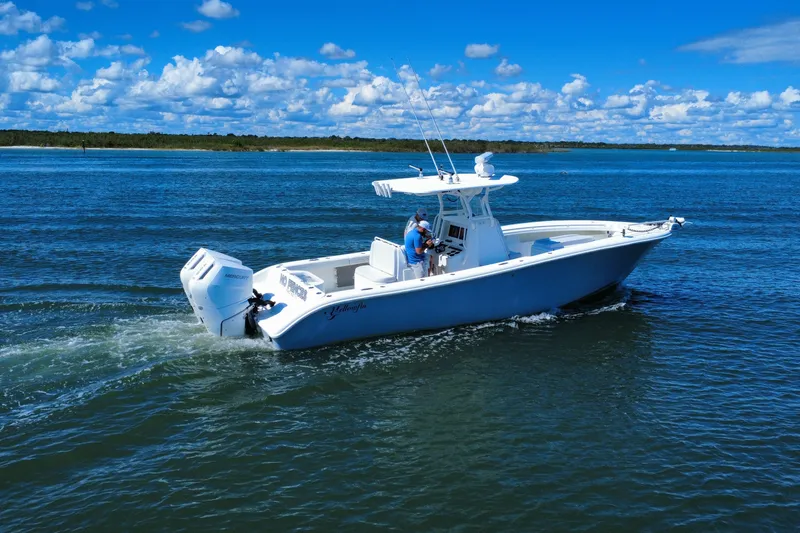 Slide: The Image of 2010 Yellowfin 32 Offshore boat cruising on open water under a clear blue sky. - 8