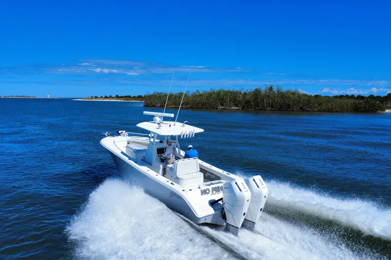 Slide: The Image of 2010 Yellowfin 32 Offshore boat cruising on a clear blue waterway. - 1
