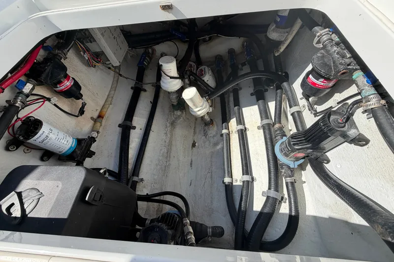Slide: The Image of Engine compartment of a 2010 Yellowfin 32 Offshore boat, showcasing pumps and wiring. - 43