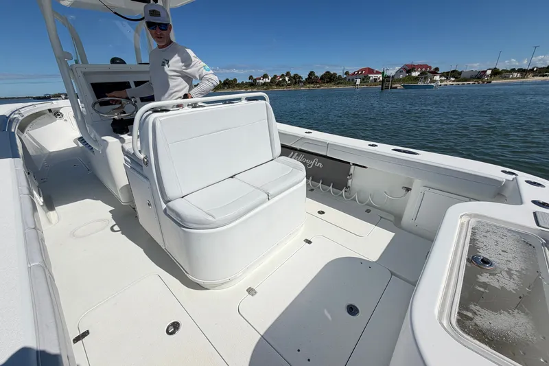 Slide: The Image of 2010 Yellowfin 32 Offshore boat interior with seating and steering, docked by the water. - 33