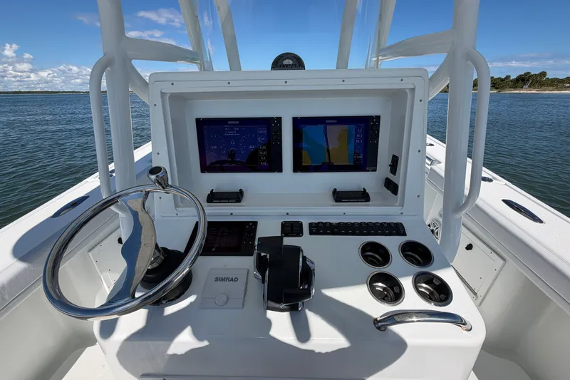 Slide: The Image of Helm of 2010 Yellowfin 32 Offshore boat with dual Simrad displays and steering wheel. - 35
