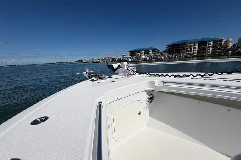 Slide: The Image of 2010 Yellowfin 32 Offshore boat docked near waterfront buildings under clear blue sky. - 16