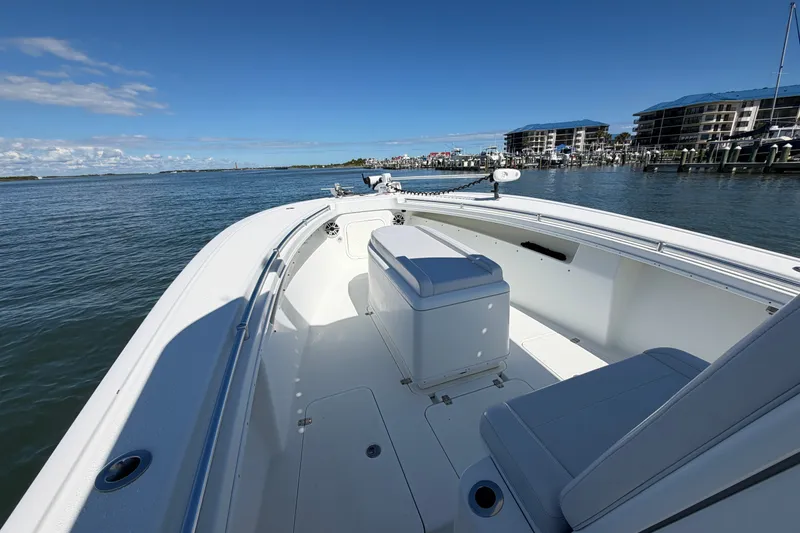 Slide: The Image of 2010 Yellowfin 32 Offshore boat on calm waters near marina buildings. - 14