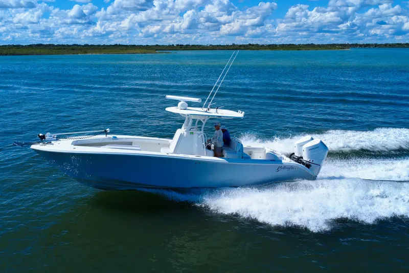 Slide: The Image of 2010 Yellowfin 32 Offshore boat cruising on open water under a blue sky. - 3