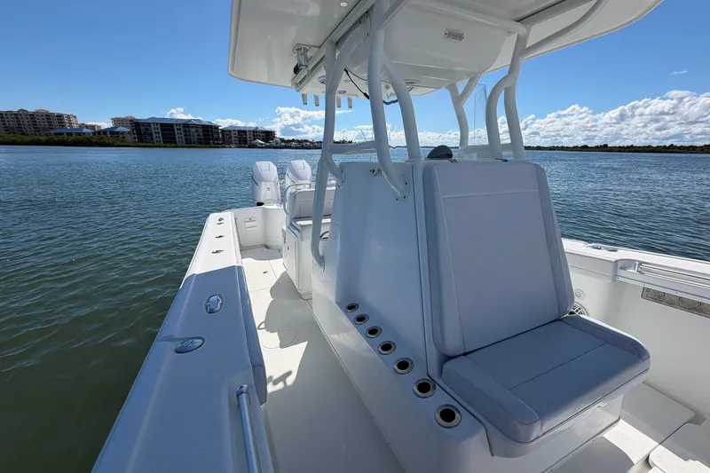 Slide: The Image of 2010 Yellowfin 32 Offshore boat on calm water, featuring spacious seating and clear skies. - 41