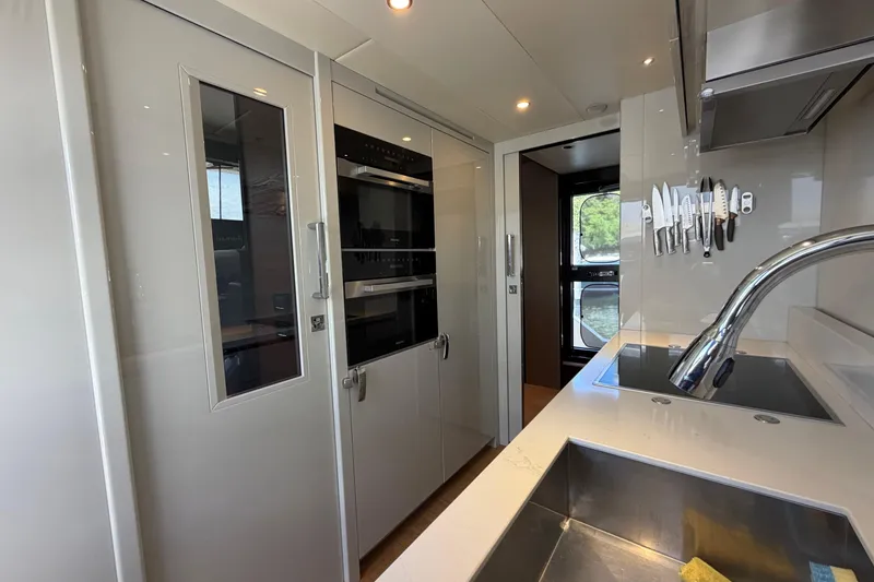 Slide: The Image of Modern kitchen interior on 2024 Absolute Navetta 75 yacht, featuring sleek appliances and stainless steel sink. - 5