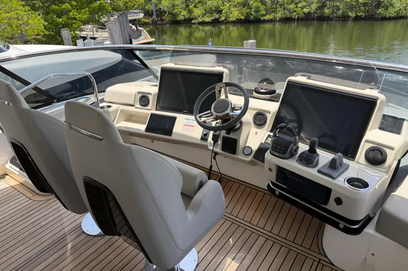 Slide: The Image of Cockpit of 2024 Absolute Navetta 75 yacht with modern controls and dual seats. - 17