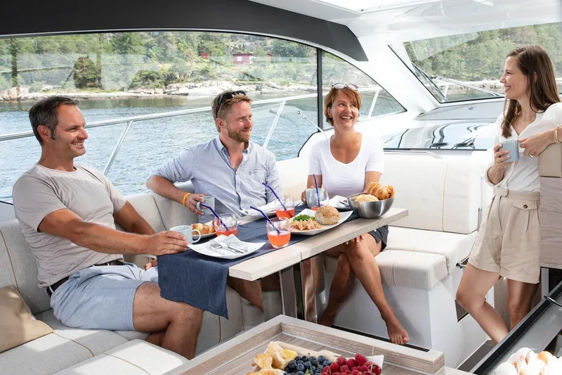 Slide: The Image of Vier Personen genießen eine Mahlzeit auf einem Boot mit Blick auf das Wasser. - 32