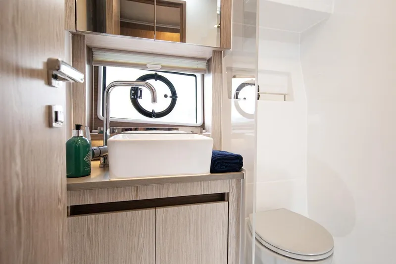 Slide: The Image of Das Badezimmer der Sealine C390 von 2027 zeigt ein modernes Waschbecken, eine Toilette und ein Fenster. - 49