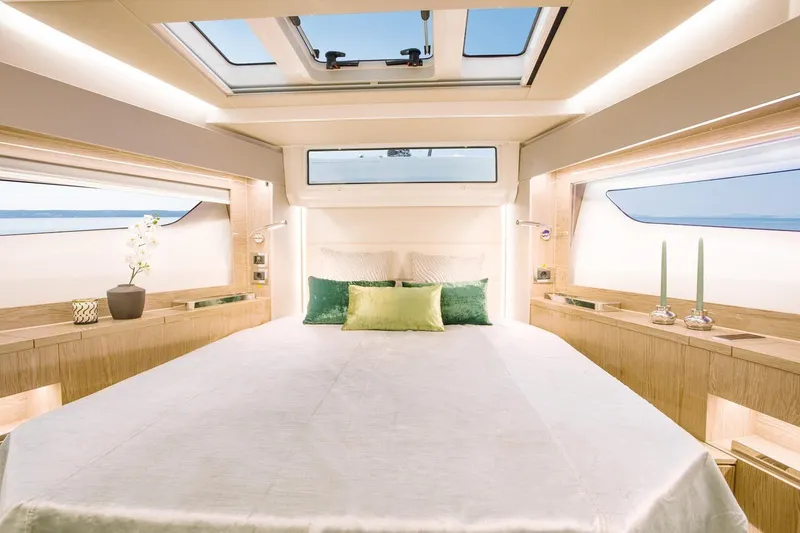 Slide: The Image of Das Bild zeigt eine luxuriöse Kabine mit einem großen Bett, modernen Leuchten und großen Fenstern. - 41