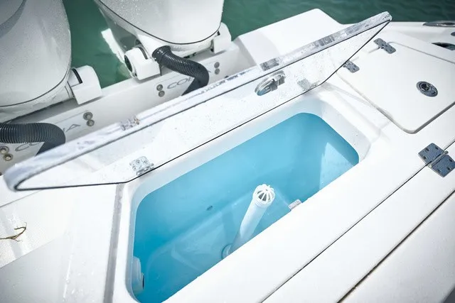 Slide: The Image of An open storage compartment on a Cobia 250 DC boat, revealing a blue interior. - 21