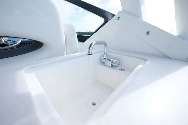Slide: The Image of A modern sink with a faucet on a boat, surrounded by white interior. - 16