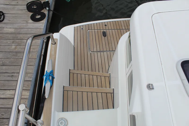 Slide: The Image of Lagoon Power 43 yacht deck, 2004 model, featuring wooden steps and dockside view. - 29