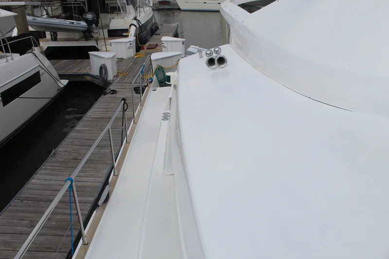Slide: The Image of 2004 Lagoon Power 43 yacht docked at marina, showcasing sleek white deck design. - 25