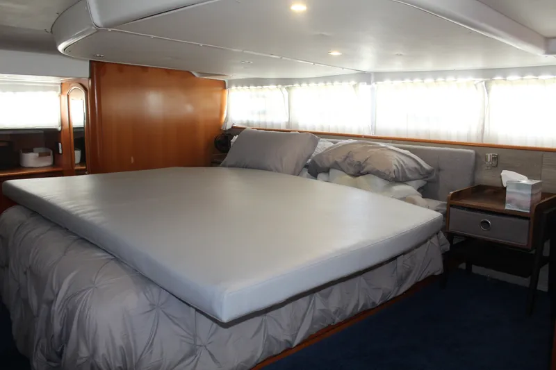 Slide: The Image of Luxurious bedroom interior of 2004 Lagoon Power 43 yacht with cozy bedding and wooden accents. - 44