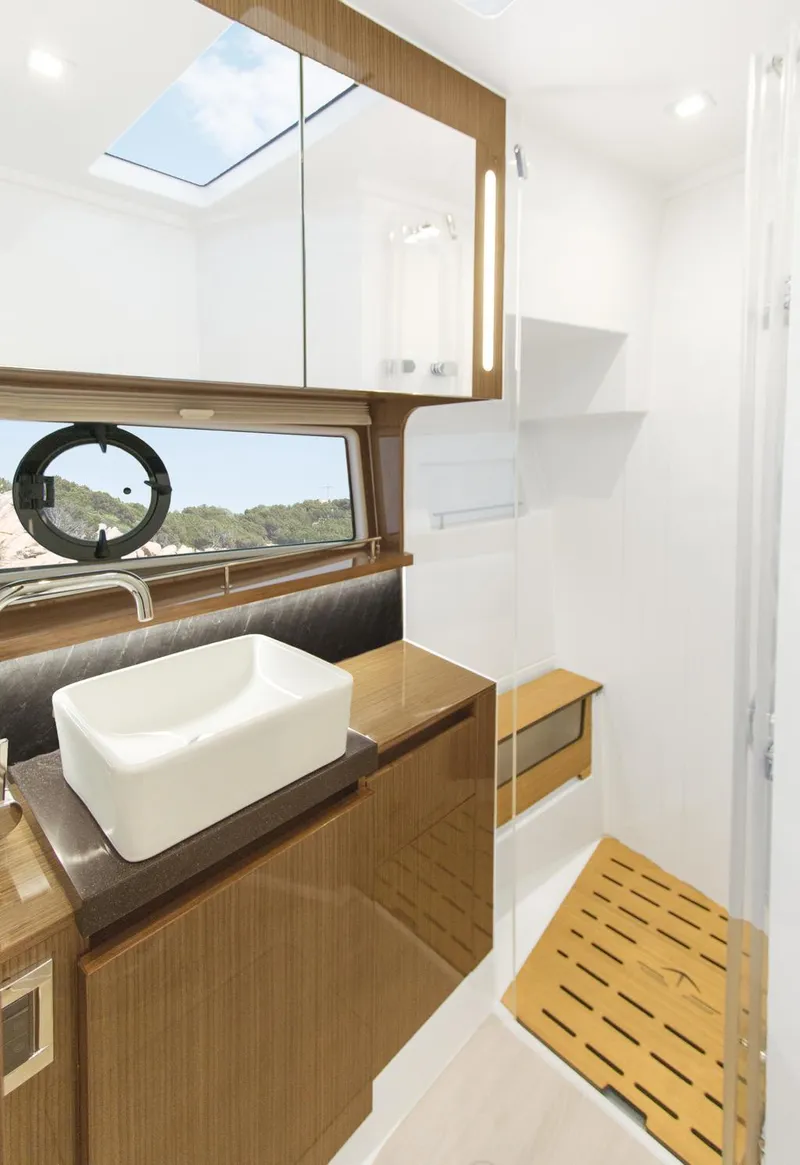 Slide: The Image of 2026 Sealine C430 yacht bathroom with modern sink, wooden accents, and skylight. - 33