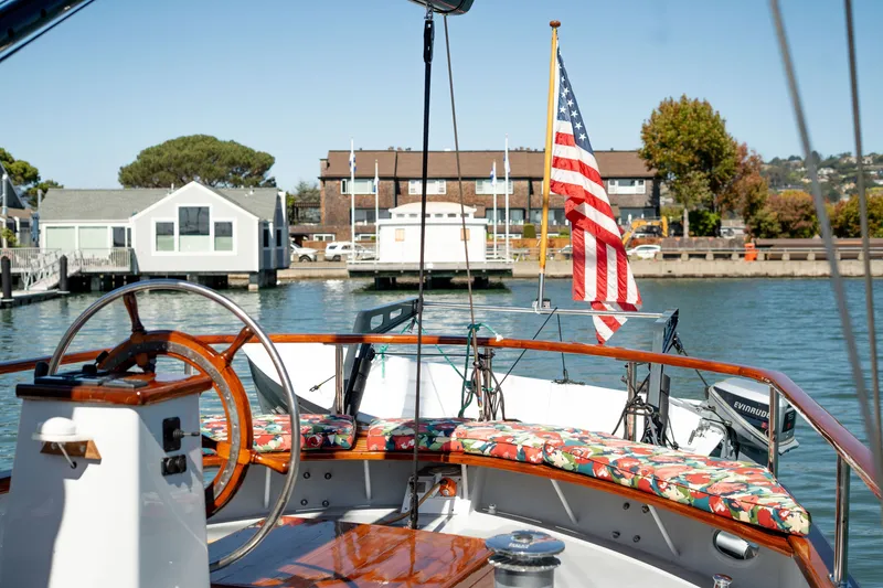 Slide: The Image of Cockpit of 1981 Thackwray Motorsailor with American flag, docked near waterfront homes. - 36