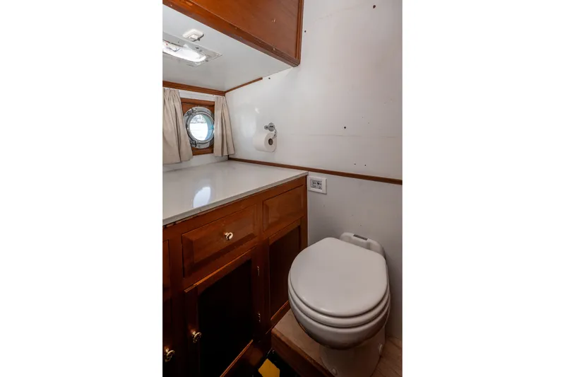 Slide: The Image of Bathroom interior of 1981 Thackwray Motorsailor with wooden cabinetry and porthole window. - 102