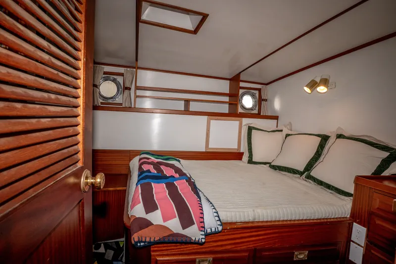 Slide: The Image of Cozy cabin interior of 1981 Thackwray Motorsailor with bed, portholes, and wooden accents. - 114
