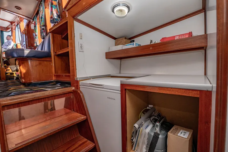 Slide: The Image of Interior of 1981 Thackwray Motorsailor with wooden stairs, storage, and seating area. - 85