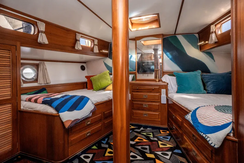 Slide: The Image of Luxurious 1981 Thackwray Motorsailor cabin with wooden interiors and colorful bedding. - 105