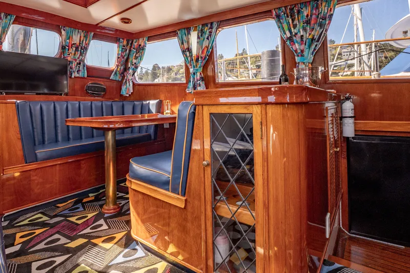 Slide: The Image of Interior of 1981 Thackwray Motorsailor with wood finish, blue seating, and colorful curtains. - 83