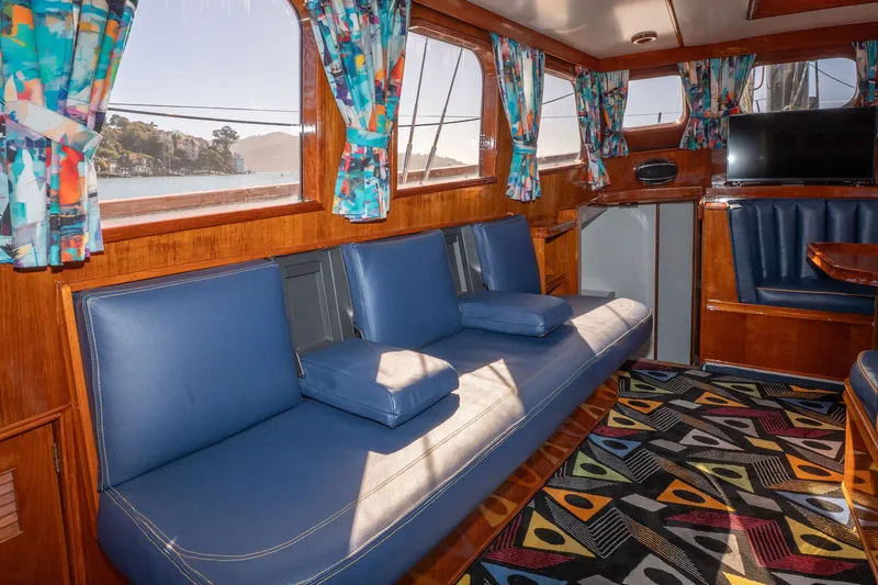 Slide: The Image of Interior of 1981 Thackwray Motorsailor with blue seating, colorful curtains, and patterned carpet. - 116