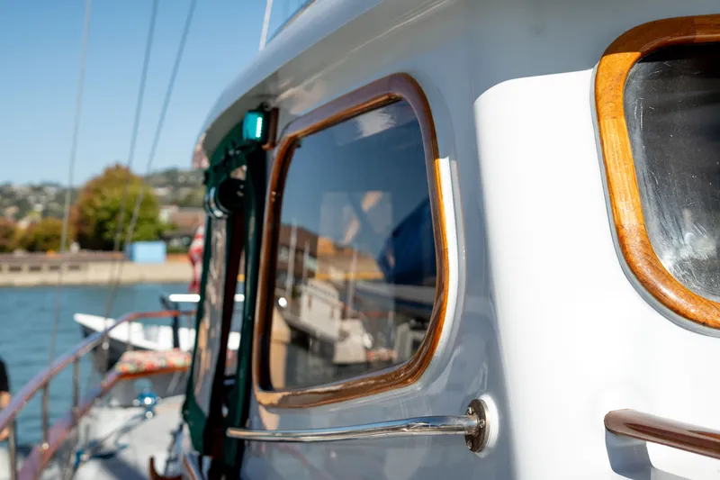 Slide: The Image of 1981 Thackwray Motorsailor yacht with wooden trim, docked by the water. - 42