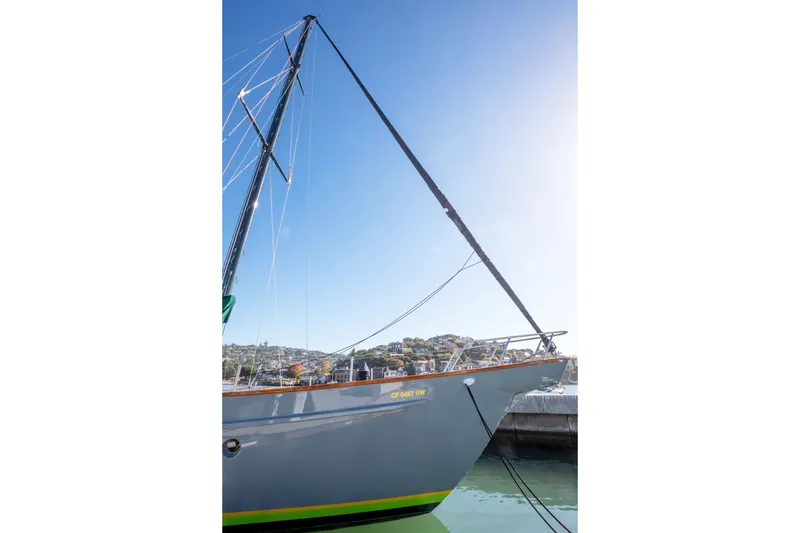 Slide: The Image of 1981 Thackwray Motorsailor yacht docked, with clear blue sky and distant hillside view. - 24