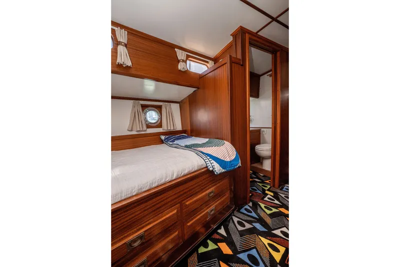 Slide: The Image of Cozy cabin interior of 1981 Thackwray Motorsailor with wooden furnishings and colorful carpet. - 101